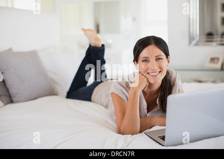 Frau mit Laptop am Bett Stockfoto