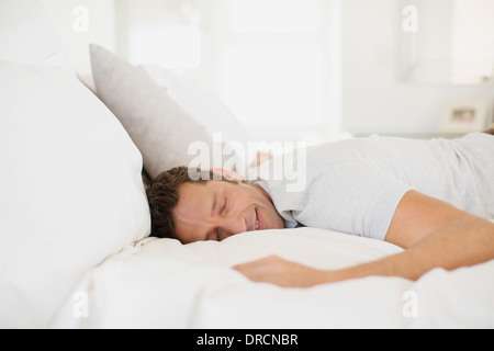 Mann schläft auf Bett Stockfoto