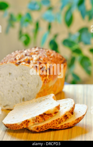 In Scheiben geschnitten Laib Weißbrot auf hölzernen Hintergrund Stockfoto