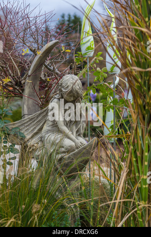 Engelsstatue mit Flügeln im bunten Garten Stockfoto
