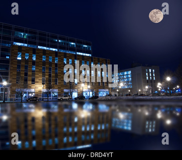 Bürogebäude am Franklin street in der Innenstadt von Syracuse, New York, im Winter nachts spiegelt sich in nassen Parkplatz Stockfoto