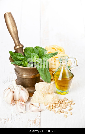 Zubereitung Pesto im Mörser auf weißem Holz Hintergrund Stockfoto