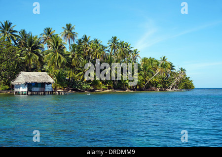 Tropische Küste mit einer rustikalen Hütte auf Stelzen über dem Wasser, Insel Bastimentos, Bocas del Toro, Panama, Karibik Stockfoto