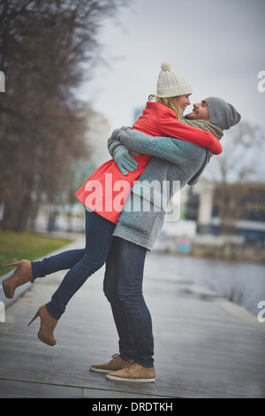 Porträt der glückliche Mann hält seine Freundin außerhalb Stockfoto