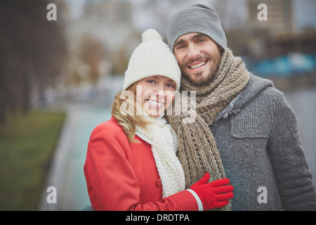 Bild des glücklichen Paares in warme Kleidung, Blick in die Kamera außerhalb Stockfoto