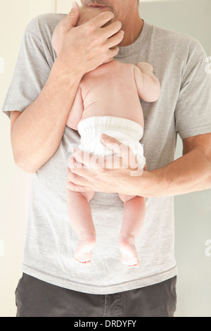 Vater Holding Neugeborenes in eine Windel Stockfoto