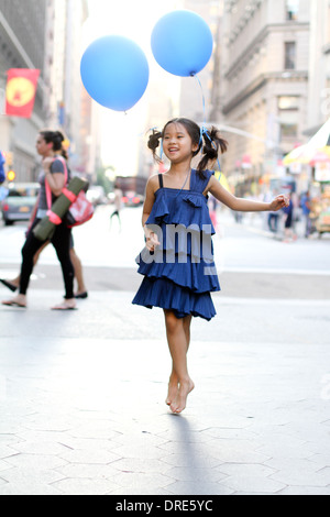 Mädchen im blauen Kleid mit blauen Ballon Stockfoto