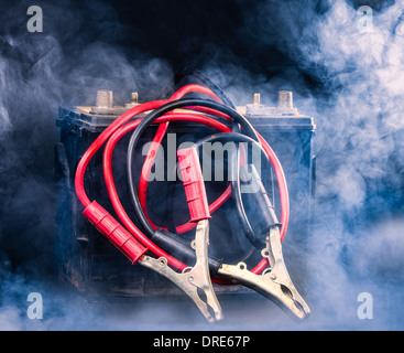 Alte Autobatterie und die Jumper-Kabel, rauchigen Umgebung Stockfoto