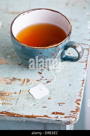 Tasse Tee mit Teebeutel auf blauem Hintergrund Textur Stockfoto