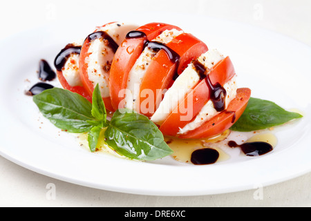 Caprese Salat Tomate und Mozzarella-Scheiben mit Basilikumblättern auf weißem Hintergrund Stockfoto