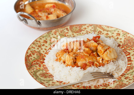 Grundlegende Fisch-Curry, in einer pikanten Sauce aus Tomaten und Kokosmilch auf einem Bett von Basmati-Reis mit einer Kadai (Karahi oder Wok) Schüssel Stockfoto