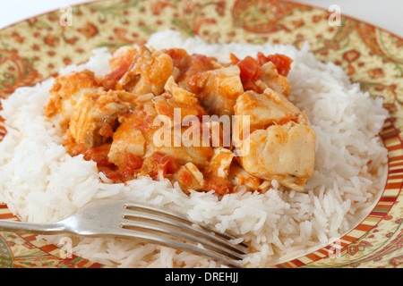 Grundlegende Fisch curry in einer würzigen Tomaten-Kokosmilch-Sauce, serviert auf einem Bett von Basmati-Reis. Stockfoto