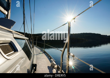 Segelboot Verankerung in ruhigem Wasser. Sonne spiegelt sich im Wasser. Foto von Kroatien, Adria Stockfoto