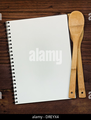 Leerer Ringbinder mit textfreiraum für Menü oder Rezepte auf einer rustikalen hölzernen Tischplatte mit Küchenutensilien. Stockfoto