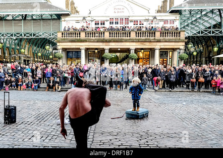 Ein Schlangenmensch unterhält das Publikum in Covent Garden Piazza. Stockfoto