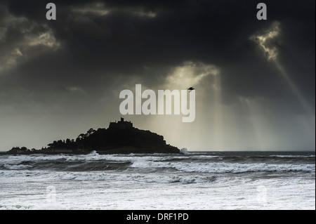 Sonnenlicht durchbrechen Gewitterwolken über St Michaels Mount in Cornwall. Stockfoto