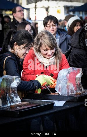 Mitglieder der öffentlichen, Eis Bildhauerei als Teil des London Ice Sculpture Festival zu erproben. Stockfoto