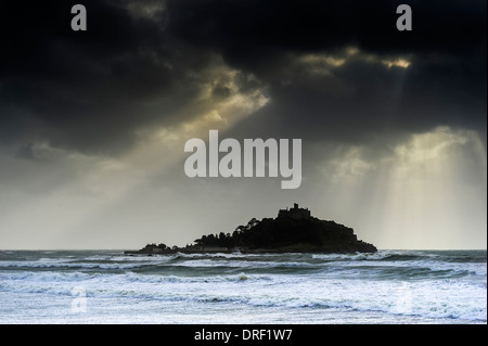 Sonnenlicht durchbrechen Gewitterwolken über St Michaels Mount in Cornwall. Stockfoto