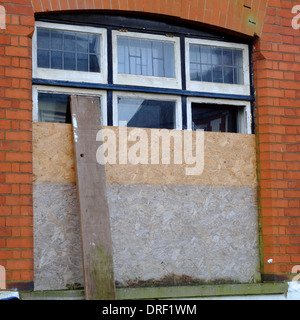 Mit Brettern vernagelt Fenster auf verlassenen herrenloses gut in Luton Stockfoto