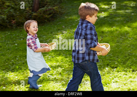 Zwei Kinder, die die Körbe In den Garten, München, Bayern, Deutschland Stockfoto