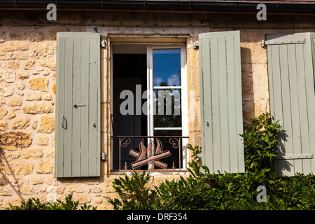Domme, Dordogne, Frankreich, Europa. Alte Fenster mit hölzernen Fensterläden auf einer alten traditionellen Gebäude aus Stein. Stockfoto