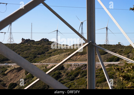 Schauen Sie durch Elektrizität Mast mit Windkraftanlagen Landschaft. Tarifa, Cádiz, Andalusien, Spanien. Stockfoto