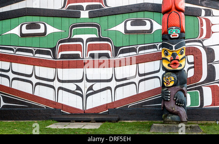 Ein Hand geschnitzte Totempfahl steht neben anderen einheimischer Kunst in Victoria, British Columbia, Kanada Stockfoto