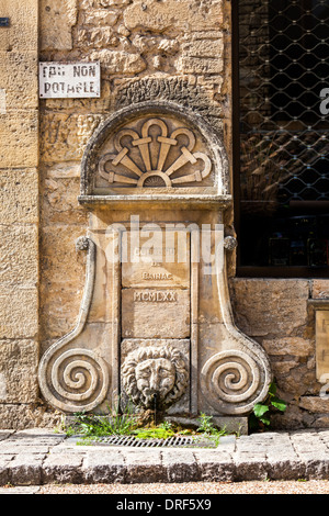 Beynac-et-Cazenac, Dordogne, Frankreich, Europa. Stein Wasser Brunnen an der Seite der Straße. Stockfoto