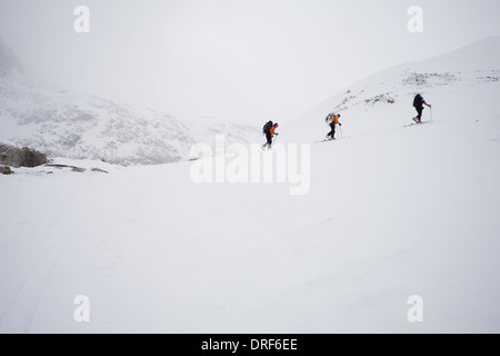 Alberta, Kanada. Drei Skifahrer aufsteigender Grat Nebel cloud-Kanada Stockfoto