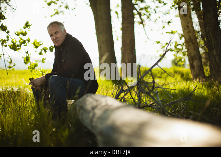 Colorado USA Mann sitzt auf gefallenen Baumstamm im Wald Stockfoto