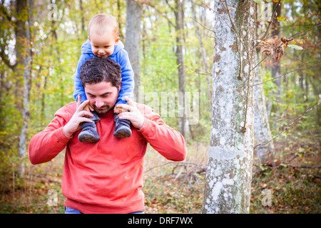 Vater gibt Sohn eine Schulter Fahrt im herbstlichen Wald, Osijek, Kroatien Stockfoto