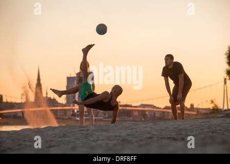 Junge Leute am Strand spielen Fußball, Drau, Osijek, Kroatien Stockfoto