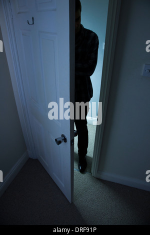 Silhouette eines Mannes in der Dunkelheit in eine offene Tür stehen. Stockfoto