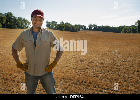 New York State USA Mann stand durch frisch gepflügten Feld Stockfoto