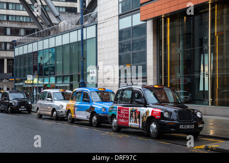 Bunte Taxis geparkt in St Mary Gate Hackney Kabinen, Private Hire Fahrzeuge im Stadtzentrum von Manchester, Lancashire, UK Stockfoto