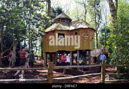 Kinder und Eltern rund um das Baumhaus im Wald bei RHS Garden Harlow Carr, Harrogate, Yorkshire. Stockfoto