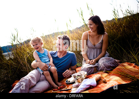 Junge Familie mit einem Kind am See, ein Picknick, Bayern, Deutschland Stockfoto