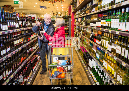 Älteres Ehepaar kauft in einem Supermarkt. Abteilung für Wein und Spirituosen. Stockfoto