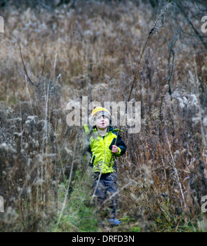 lächelnde junge kleine Junge 5-Year-Old Boy zu Fuß in ein Feld im Winter Stockfoto