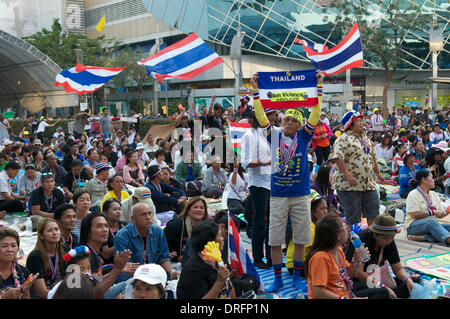 Bangkok, Thailand. 24. Januar 2014. Ein Anti-Regierungs-Demonstranten hält ein Gewaltlosigkeit Schild eine thailändische Nationalflagge vor der Hauptbühne mit MBK Einkaufszentrum an der Kreuzung Pratunam befestigt. Nach fast 3 Monaten protestieren gibt es immer noch Zehntausende von Demonstranten auf den Straßen von Bangkok fordern den Rücktritt von Ministerpräsident Thailands Yingluck Shinawatra. "Shutdown Bangkok" ist durch das Volk demokratische Reform Committee (Separatistischen) organisiert. Bildnachweis: Kraig Lieb / Alamy Live News Stockfoto