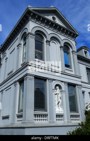 Das Äußere eines grau gestrichenen Haus Übersicht palladianischen Architektur, Rundbögen, und eine weiße Skulptur in Christies Gate in Bergen, Norwegen. Stockfoto