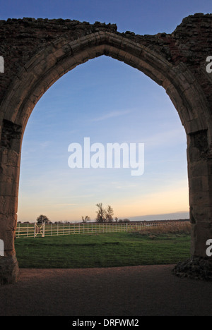 Ein Blick auf den Sonnenuntergang durch die zerstörten West Torhaus Bogen an der Abtei St. Benet, in der Nähe von Horning, Norfolk, England, Vereinigtes Königreich. Stockfoto