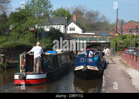 Zwei Narrowboats durch Sperre 13 von den Cheddleton Schleusen für den Caldon Kanal und Brücke 42 tragen Cheadle Straße Stockfoto