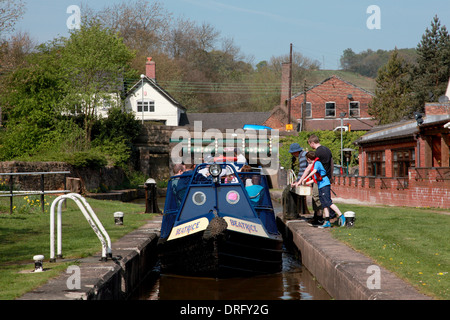 Ein Narrowboat Eingabe sperren die Cheddleton Schleusen auf dem Caldon Kanal und die Brücke 42 tragen Cheadle Straße 13 Stockfoto