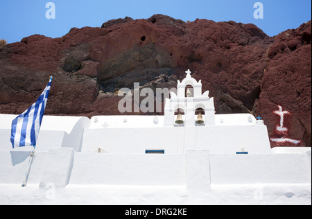 Traditionelle Kirche mit Griechenland Flagge in roter Strand, Santorin Stockfoto