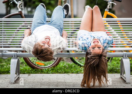 Junges Paar auf einer Bank, die Spaß haben, kopfüber, Osijek, Kroatien Stockfoto