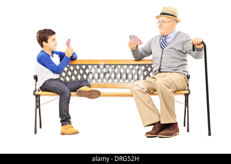 Großvater Spielkarten mit seinem Neffen auf Bank sitzend Stockfoto