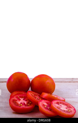 gehackte und ganze Tomaten auf Alter hacken Boarrd auf weißem Hintergrund. vertikale Stockfoto