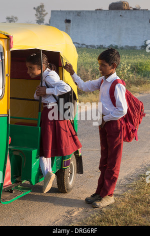 Bruder und Schwester in Schule einheitliche kennenlernen im Auto-Rikscha Stockfoto