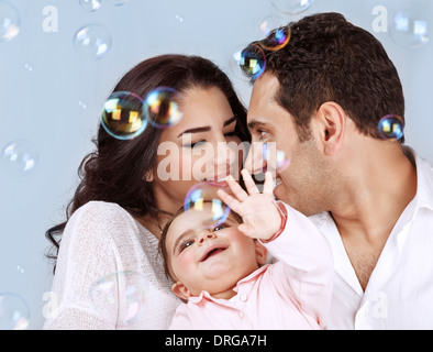 Closeup Portrait der glückliche junge Familie spielt mit Seifenblasen isoliert auf blauem Hintergrund, Spaß haben, spielen Stockfoto